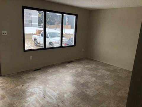 a living room with a large window and a tiled floor