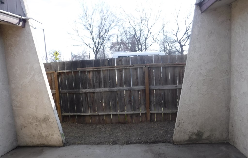 a view of the backyard from between two walls of a fence