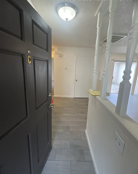 a hallway with a black door and a tile floor