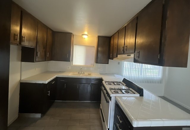a kitchen with black cabinets and a stove and a sink