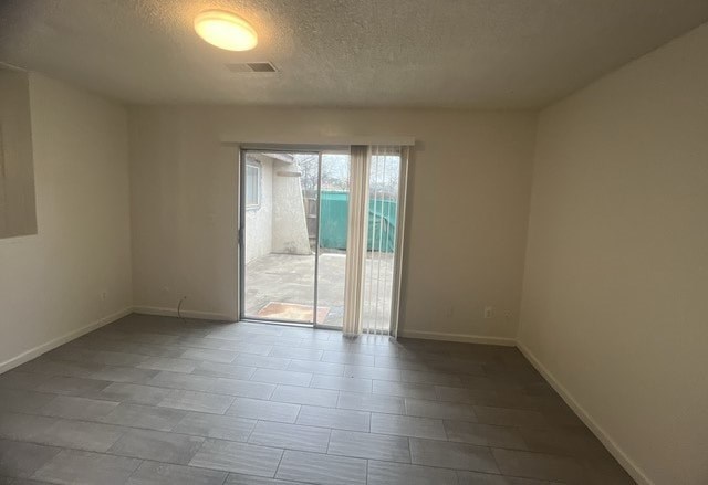 an empty living room with a sliding glass door to a pool