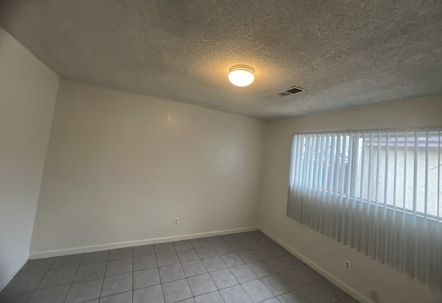 an empty living room with a large window and a ceiling light
