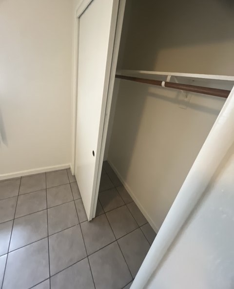 a bathroom with a closet and a tiled floor