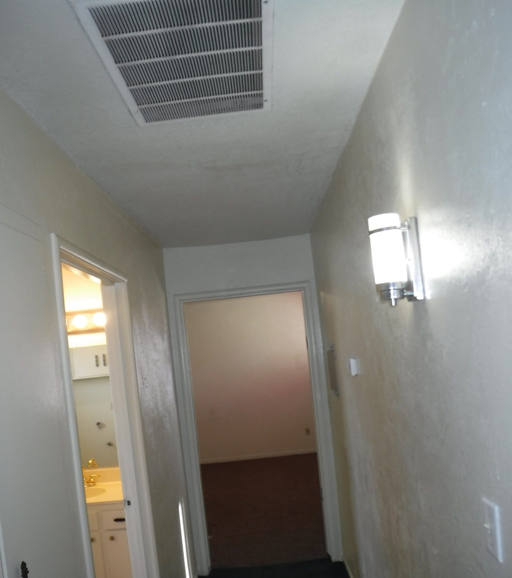 a view down a hallway with a door to a hallway and a door into a