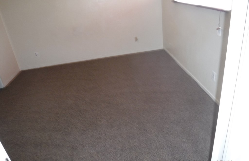an empty room with carpet and a window