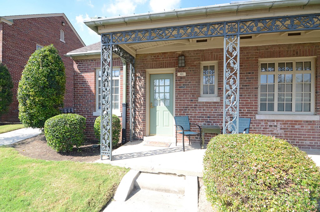 the front entrance of a brick house with a blue porch