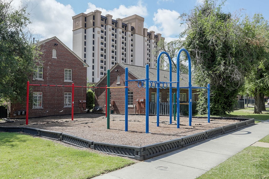 a playground in a park with a building in the background
