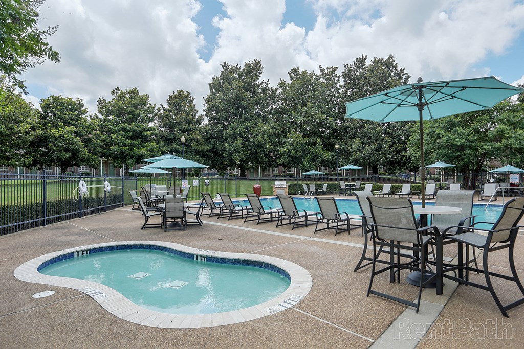 a pool with chairs and tables and umbrellas at a resort