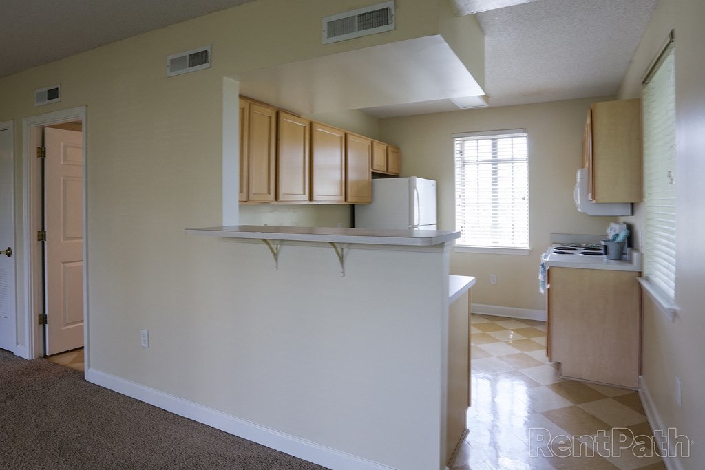 an empty kitchen with a counter and a refrigerator