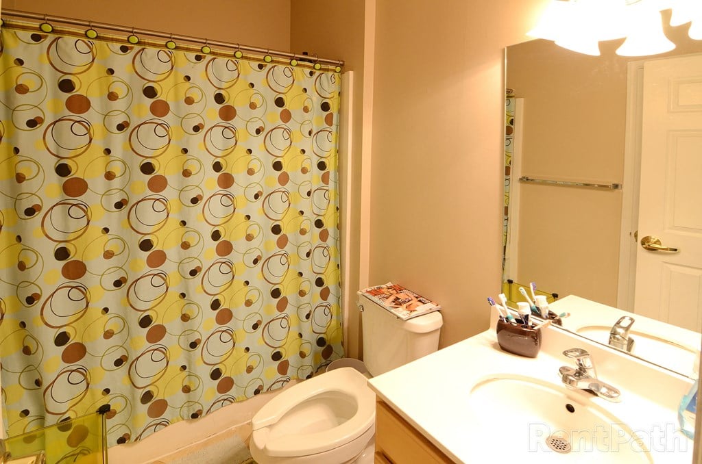a full view of a bathroom with a shower toilet and sink