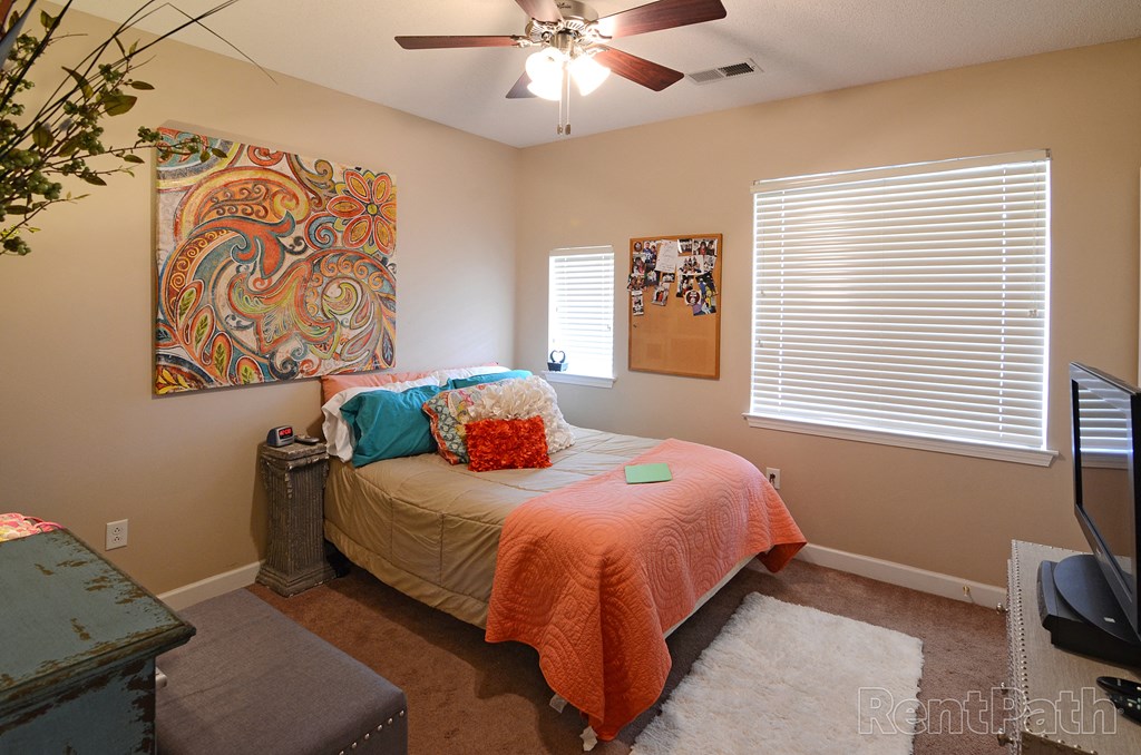 a bedroom with a bed and a ceiling fan
