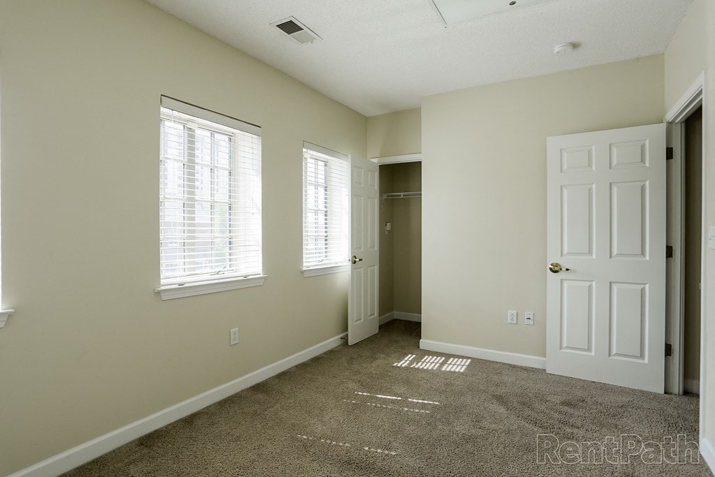 a bedroom with a carpeted floor and a white door