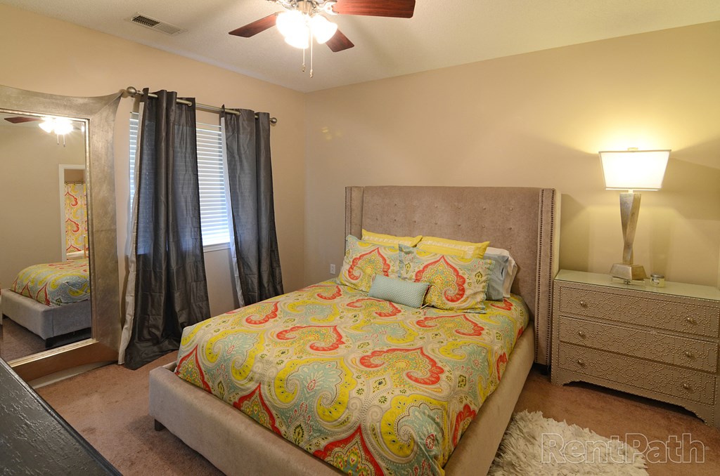 a bedroom with a bed and a ceiling fan