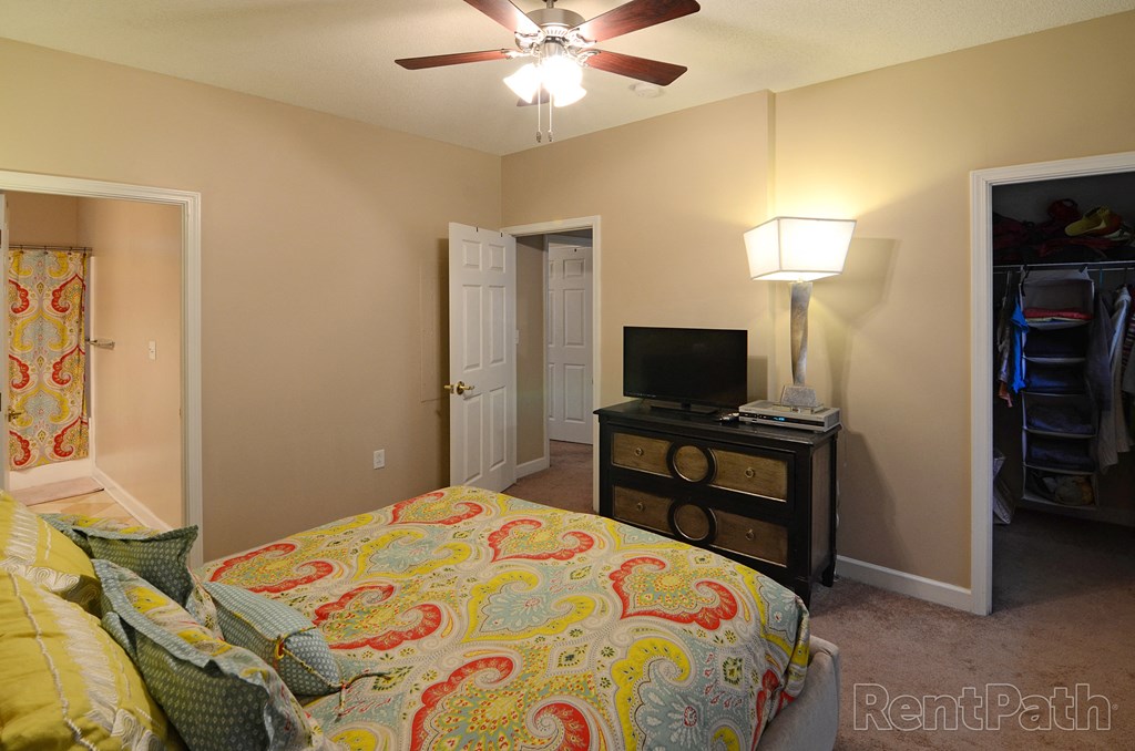 a bedroom with a bed and a ceiling fan