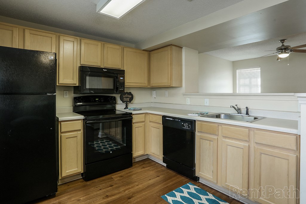 a kitchen with black appliances and wooden cabinets