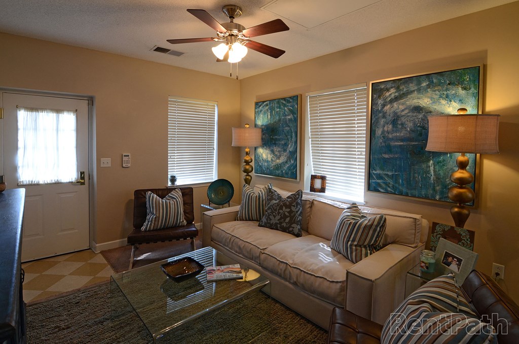 a living room with a ceiling fan and a couch