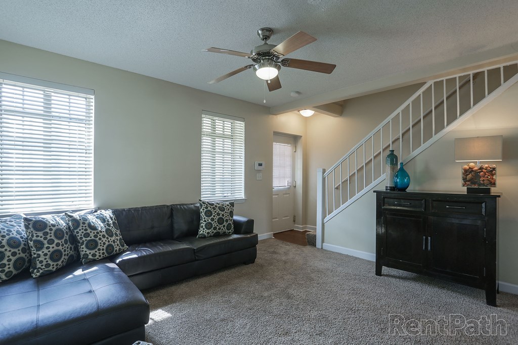 a living room with a couch and a ceiling fan