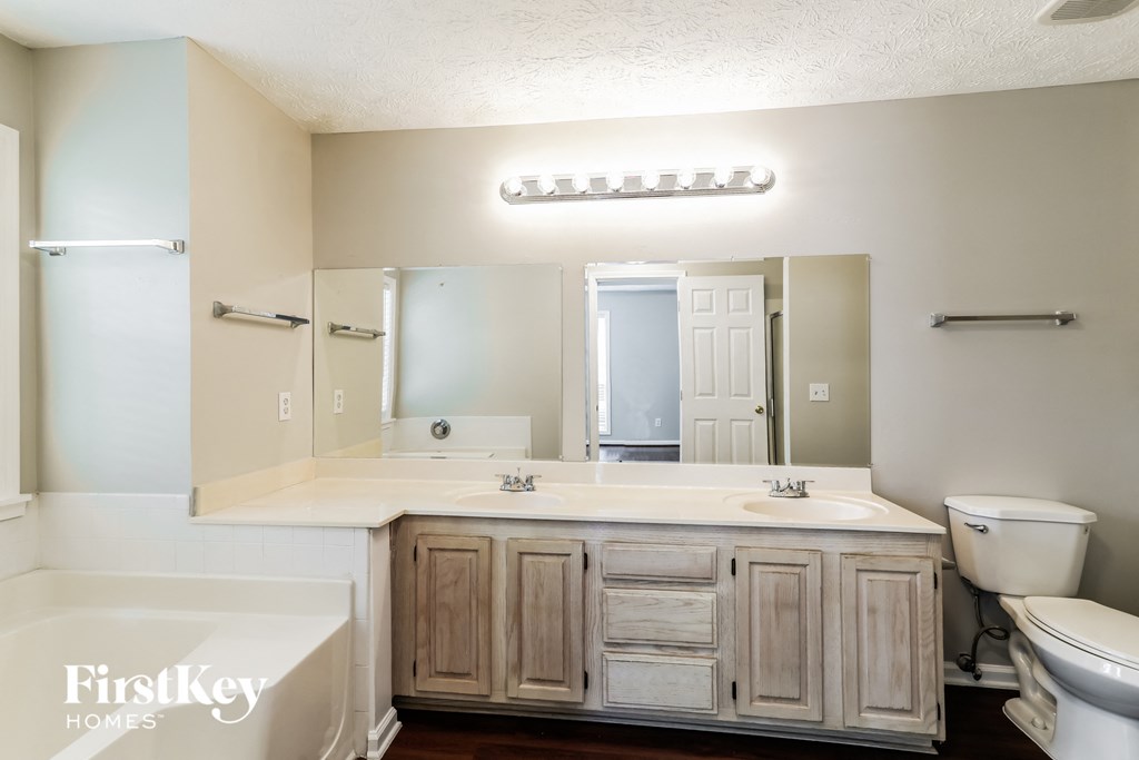 A bathroom with a white tub, sink, and toilet.