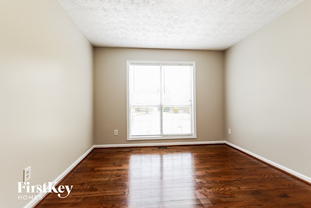 A room with wooden floors and a window letting in light.
