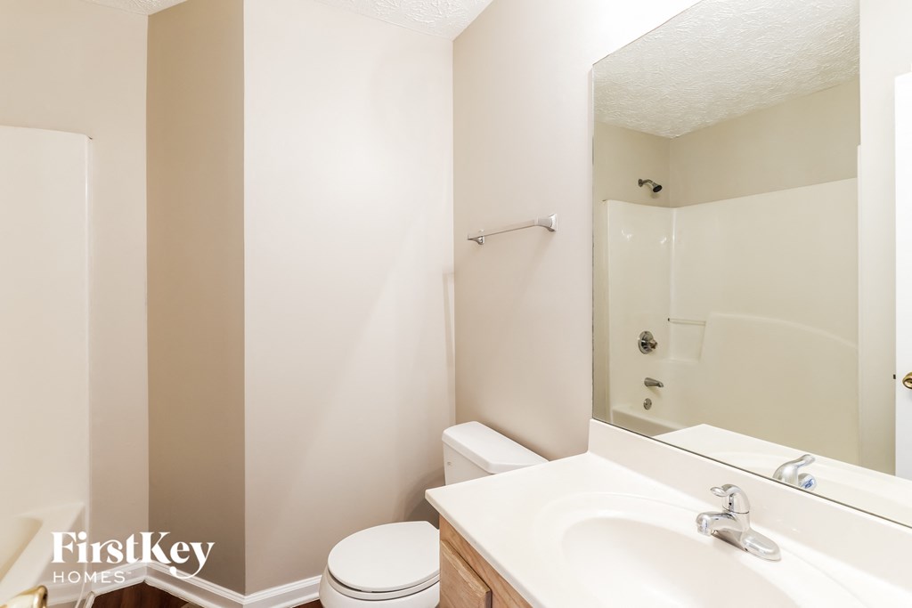 A white toilet sits next to a sink in a small bathroom.