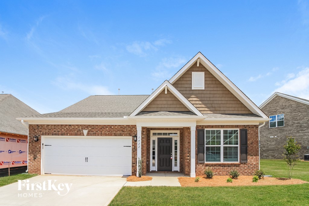 a house with a white garage door in front of a lawn