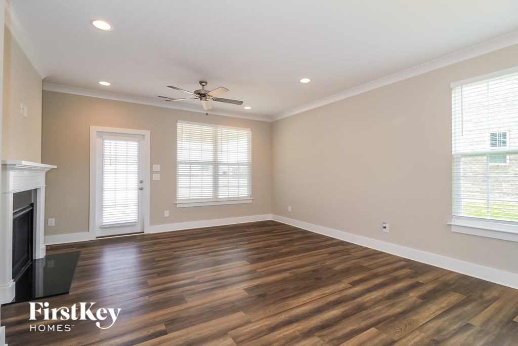a living room with a fireplace and a ceiling fan
