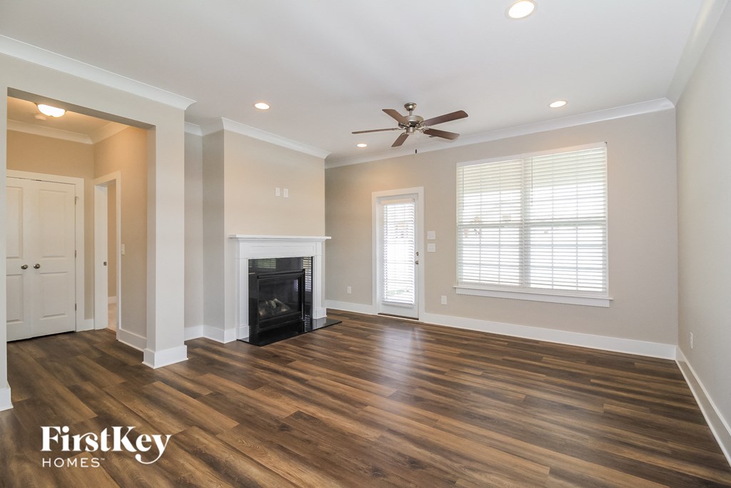 a living room with a fireplace and a ceiling fan