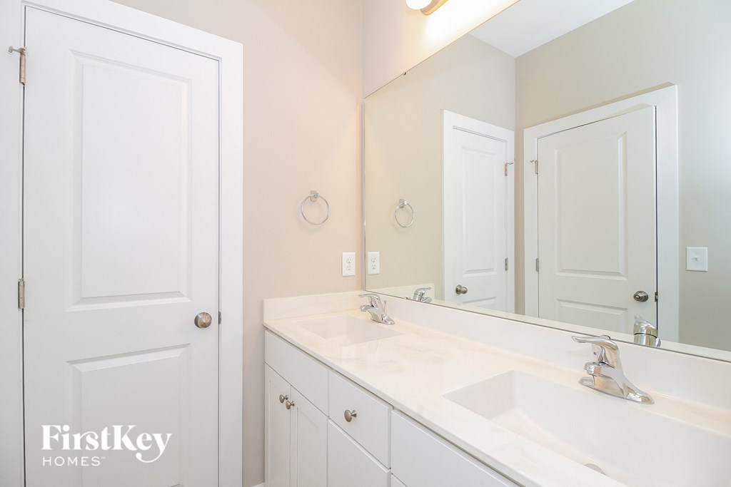 a white bathroom with two sinks and a large mirror