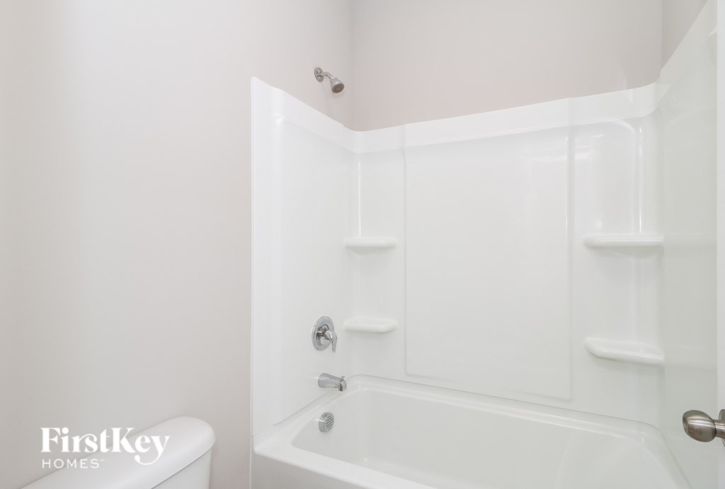 a white bathroom with a tub and a sink