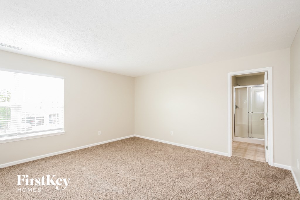 a bedroom with carpet and a door to a closet