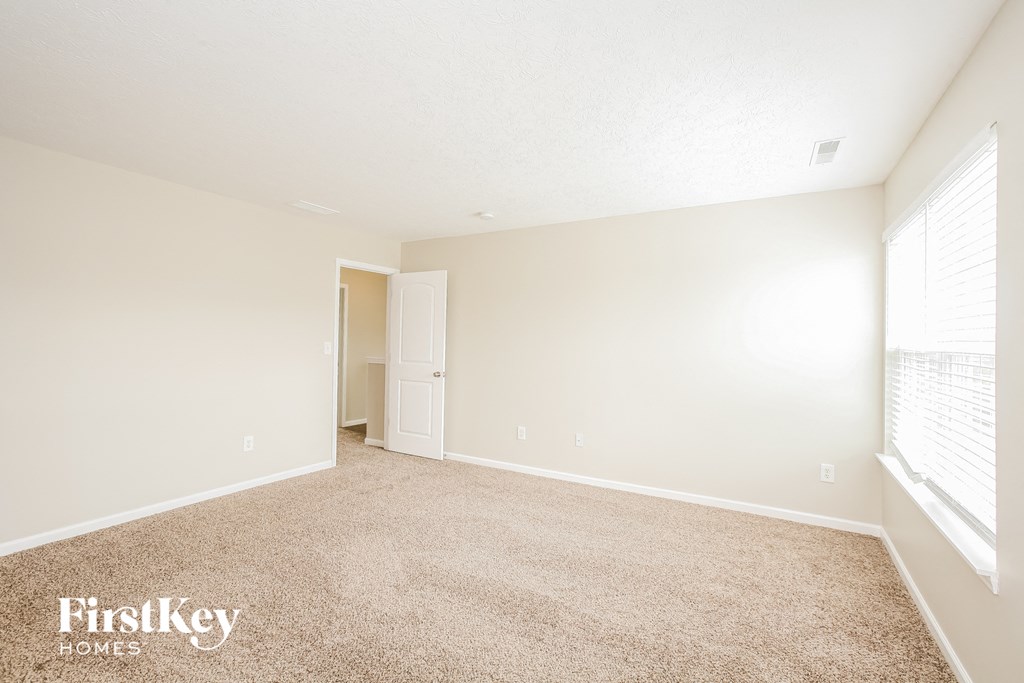 a spacious living room with carpet and a window