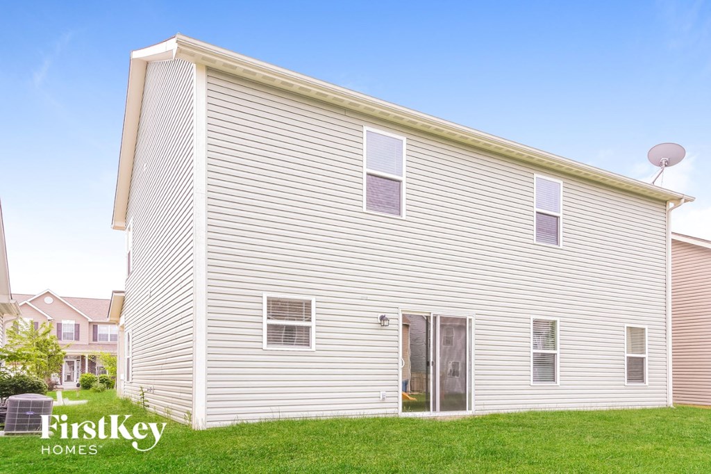 side view of a white house with white siding and a lawn