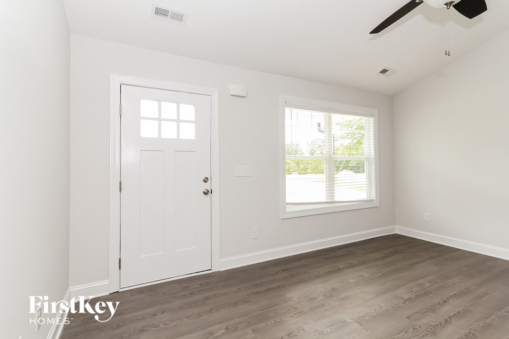 a bedroom with white walls and a white door and a window
