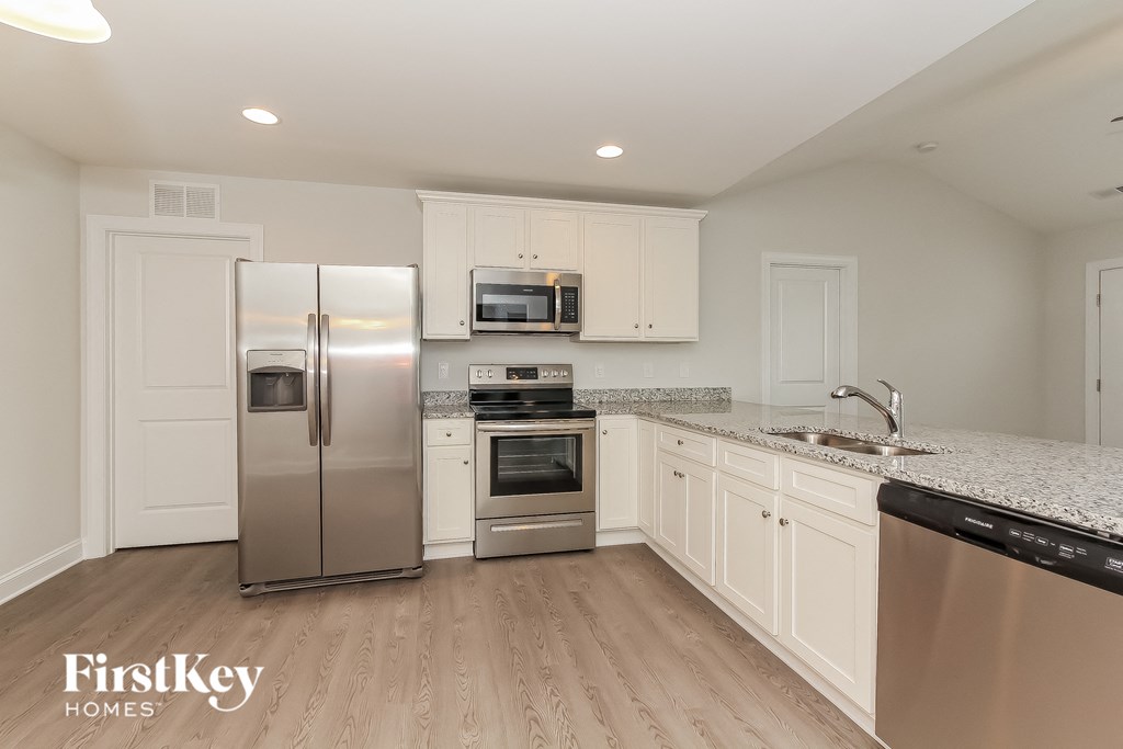 a kitchen with white cabinets and stainless steel appliances