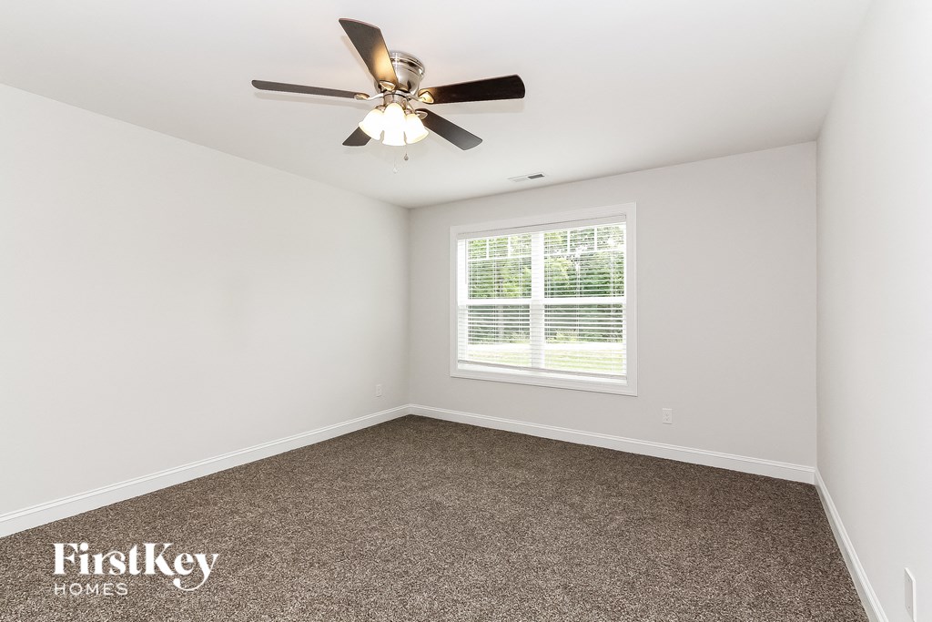 a bedroom with carpet and a ceiling fan