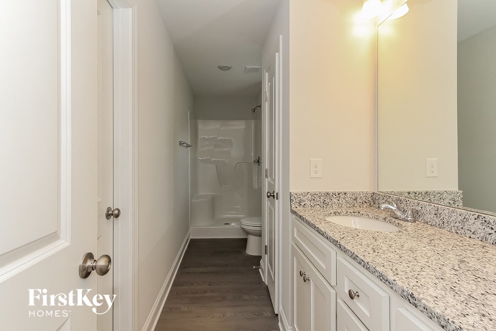 a bathroom with white cabinets and a sink and a toilet