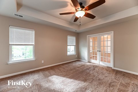 a living room with carpet and a ceiling fan