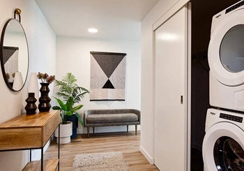 Entry foyer with washer and dryer in a closet with small bench and table and mirror - Photo Gallery 33