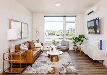Living room with windows facing north, leather sofa, mounted television - Photo Gallery 35