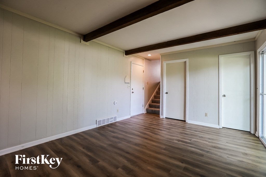 a living room with white walls and a wooden floor