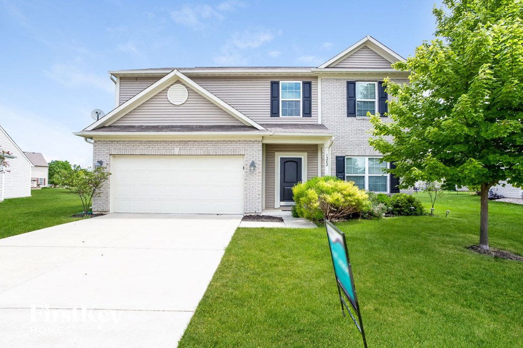 a house with a white driveway and a flag on the lawn