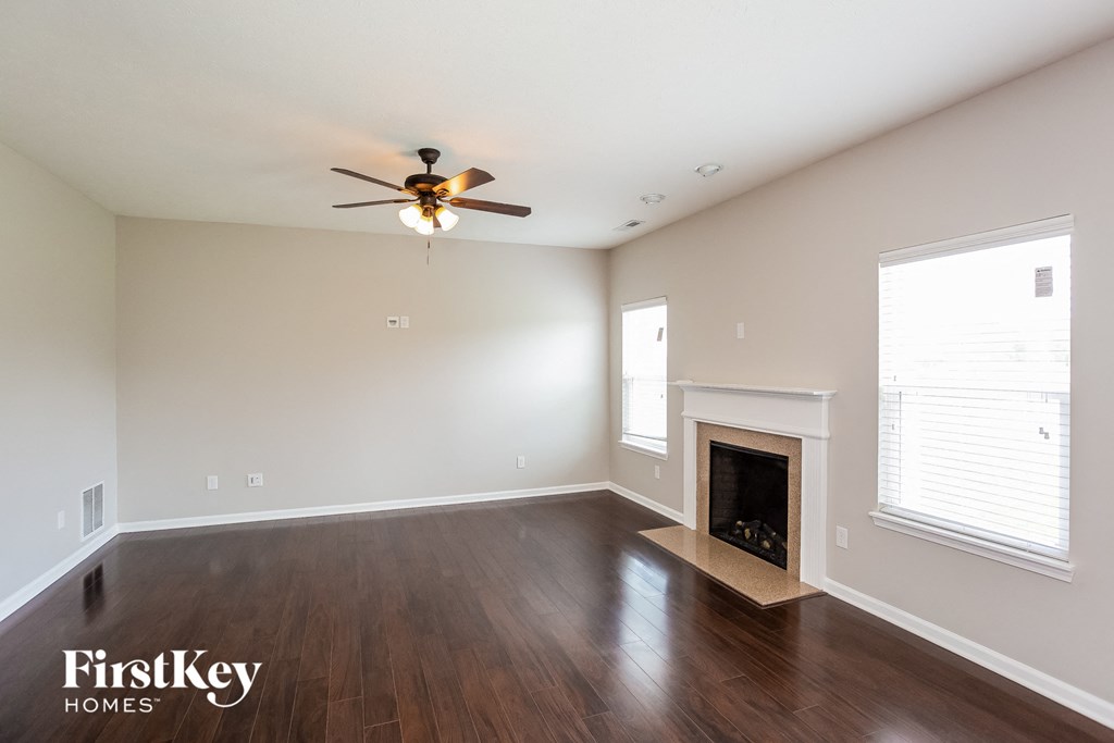 a living room with a fireplace and a ceiling fan