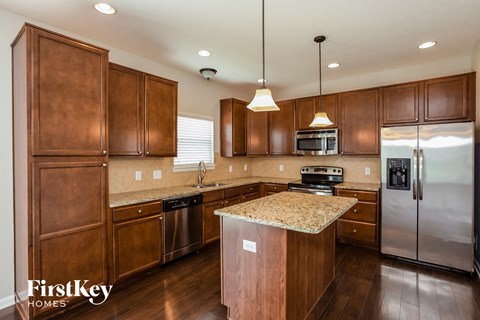 a kitchen with wooden cabinets and granite counter tops and stainless steel appliances