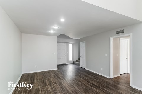 a renovated living room with white walls and wood flooring