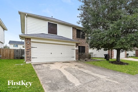 a white garage door in front of a brick house