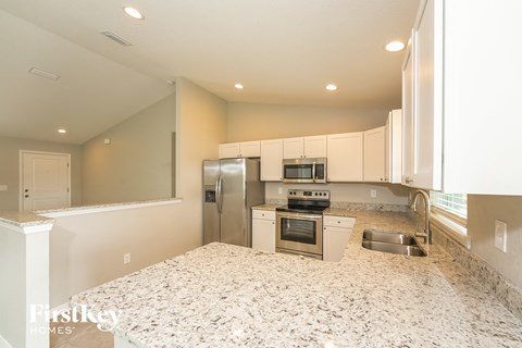 a kitchen with granite counter tops and stainless steel appliances