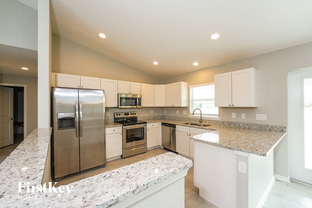 a kitchen with granite counter tops and stainless steel appliances