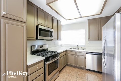a kitchen with stainless steel appliances and white counter tops