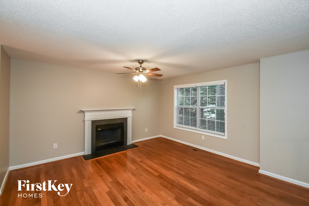 A room with a fireplace and a ceiling fan.