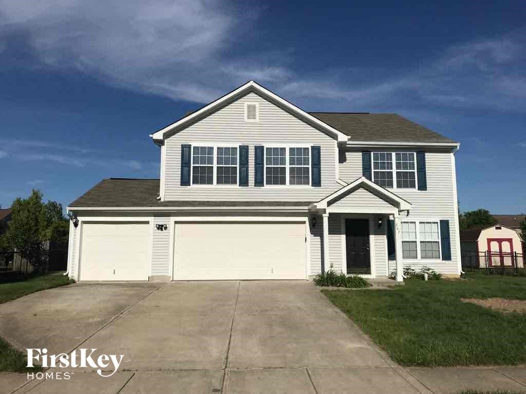A two-story house with a garage is for sale.
